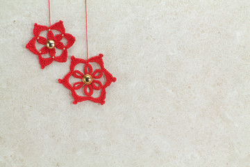 two red crochet christmas stars on sponged white background