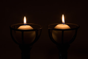 two round candle in a gothic stand dark tight flame