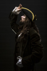 Portrait of a medieval bearded pirate on black background.