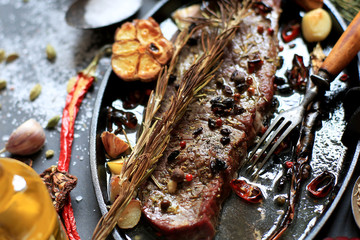 Big steak with spices in a cast iron skillet