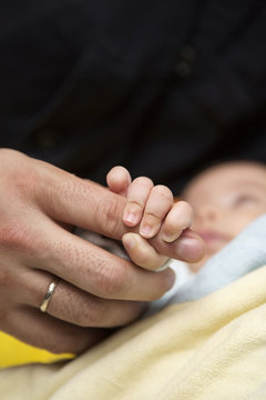 Baby holding a parent finger