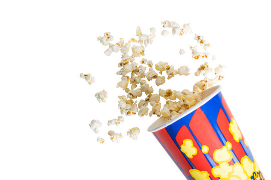 Popcorn in a white striped bucket broken up  on isolated  white background