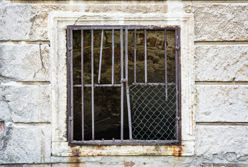 Fototapeta na wymiar Old wall with barred window