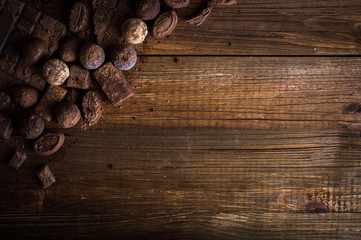 Naklejka premium chocolate candy in cocoa on a wooden table