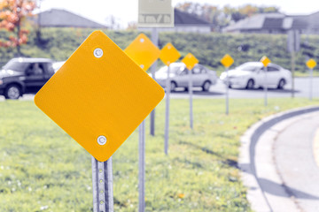 Yellow traffic signs along the turn of a highway on ramp