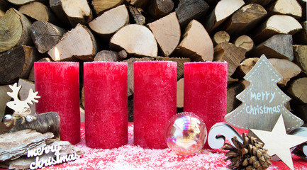 Erster Advent / Weihnachtliche, rote Kerzen vor Holzhintergrund