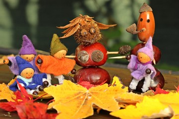 Naklejka premium Vier kleine Wichtel mit Kastanienfrau und Kastanienmann