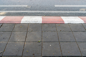 Concrete sidewalk with red and white