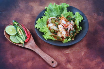 Fried spicy mixed herb  with squid and side dish.
