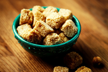 Brown sugar in a bowl on wooden background