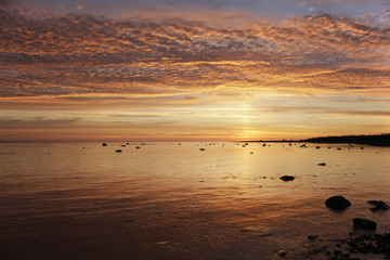 golden sunset with colored clouds and the ripples on the water