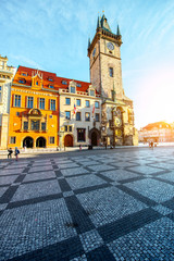 View on the beautiful buildings and town hall with clock tower during the sunrise in the old town of Prague