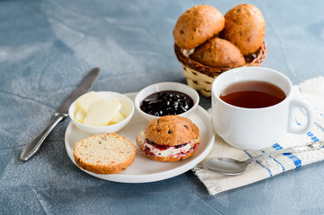 Scones with butter and jam with tea on the table