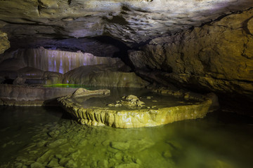 Fototapeta premium Natural speleothem, cascades of lakes and waterfalls in Nizhneshakuranskaya cave, Abkhazia, Georgia