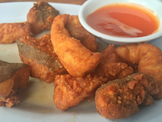 Horizontal photo of closeup fried fish with chili sauce. Shallow depth of field