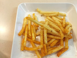 spicy french fries on white dish in restaurant, Thailand.