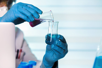 chemist working in laboratory mixing fluids / scientist holding tubes test in the chemical lab