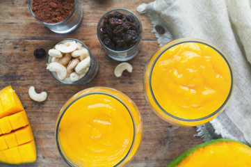 Two glasses of mango mousse. Top view. Blurred background