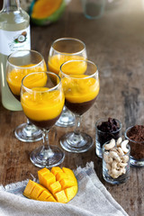 Two glasses of raw dessert with mango mousse. Blurred background