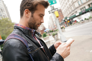 Tourist in New york city looking at city guide on smartphone