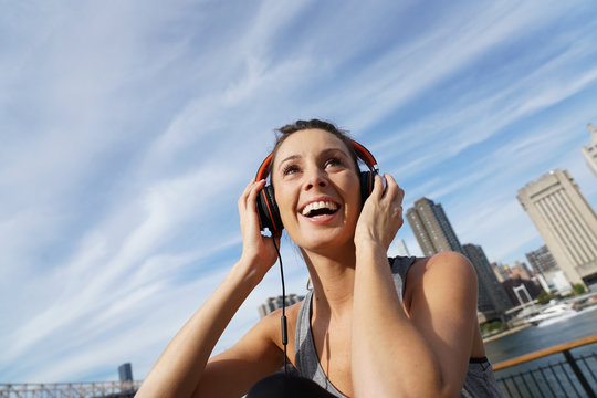 Closeup of jogger girl listening to music with headset