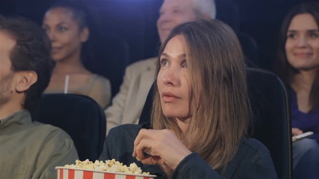 Woman Eats Popcorn At The Movie Theater