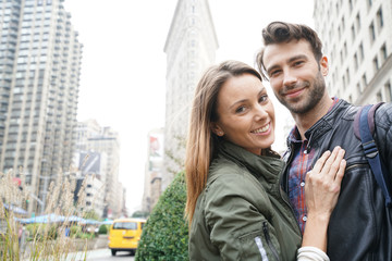 Couple of tourists standing in front of Flatiron building, NYC