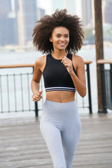 Fototapeta na wymiar Fitness girl jogging on the East river riverbanks