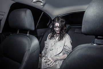 Horror zombie woman with bloody face in the car