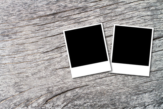 two blank photo frames on wood texture background