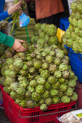 fresh artichoke selling in market with farmer's hand picking for sell, Dalat,Vietnam