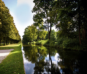 Fototapeta na wymiar Germany, Bavaria, park flanked by a channel with still waters