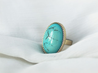 Fashionable turquoise stone ring on white background