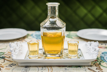 Obraz na płótnie Canvas Carafe with honey vodka on white elegant tray