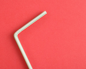 A drinking straw on a red background