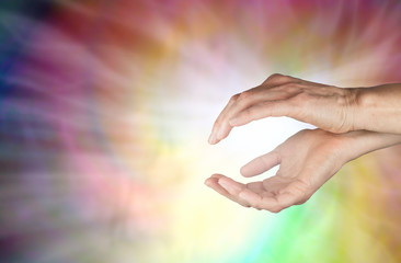 Spiraling Healing Energy - female hands held in gently cupped position with a spiraling swirl of...