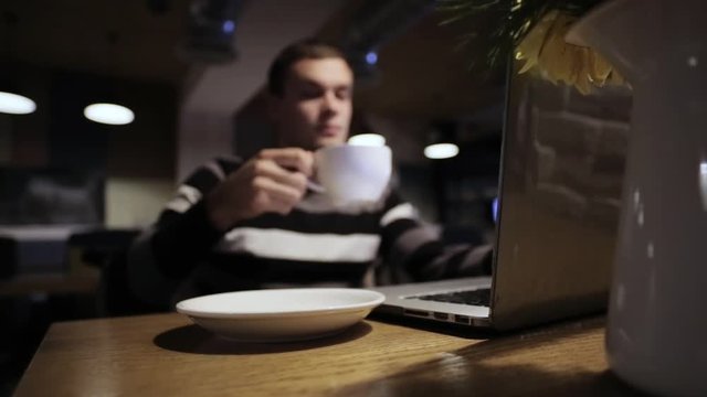 Handsome man working on laptop and drink coffee in cafe