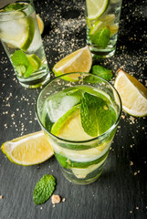 Refreshing lime mojito or tequila with ingredients for it - lime, mint, brown cane sugar. Copy space