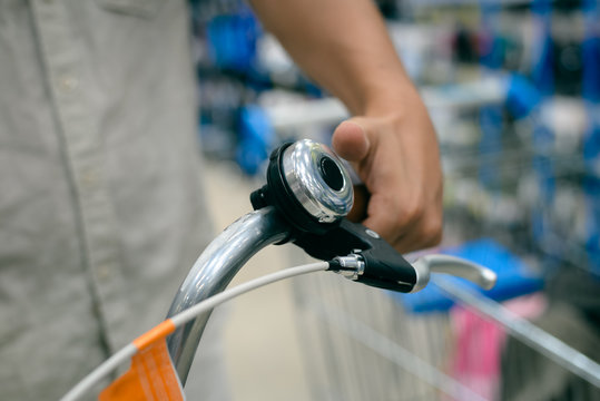 Closeup on person hand checking bicycle, shop background