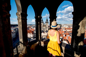 Fototapeta premium Young female tourist enjoying great view on the old town of Prague from the top of the clock tower