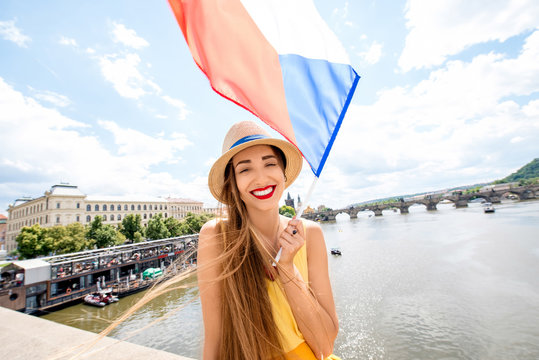 Young female tourist with czech flag traveling in Prague city. Promoting tourism in Prague