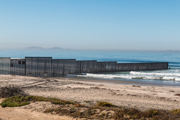 Fototapeta na wymiar Border Field State Park beach with the international border fence between Tijuana, Mexico and San Diego, California, along with the Islas Los Coronados islands in the background.