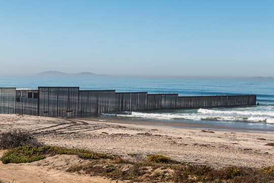 Border Field State Park beach with the international border fence between Tijuana, Mexico and San Diego, California, along with the Islas Los Coronados islands in the background.