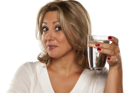 positive middle-aged woman holding a glass with water