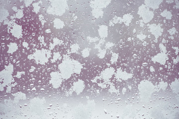 toned winter window with snow and water droplets
