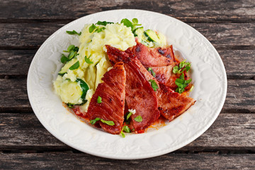 Sliced Gammon Steak with mashed potato on wooden background.
