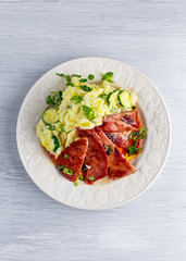 Sliced Gammon Steak with mashed potato on wooden white background.