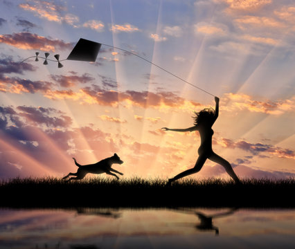 Girl with a dog running with a kite