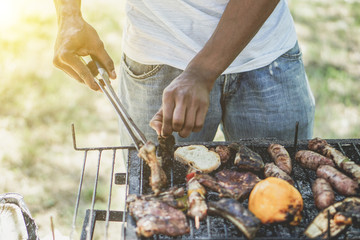 Afro american man cooking meat on barbecue 