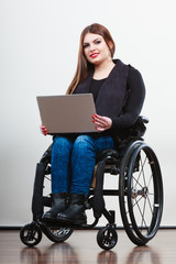 Disabled woman with laptop on wheelchair.